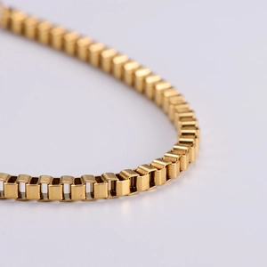 Macro shot of gold stainless steel box chain with 18k plating showing smooth metal links