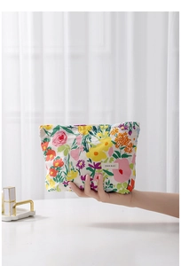 Floral print makeup bag detail showing fabric texture and H&R BAG logo label