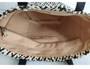 Top view of two-tone woven tote interior featuring beige lining and zipper pocket