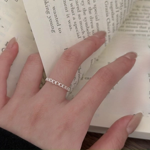 Minimalist 925 silver interwoven rope ring on model with vintage book background
