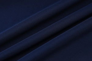 Detailed macro view of navy blue knitted fabric texture showing soft draping and quality