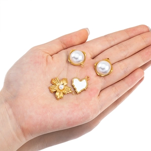Handheld view of French style floral and heart charms with pearls for DIY jewelry