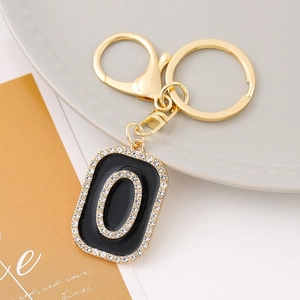 Macro detail of alphabet O keychain with black enamel and white rhinestones