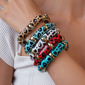 Close-up of multicolored acrylic leopard print bangles with gold spacers on wrist