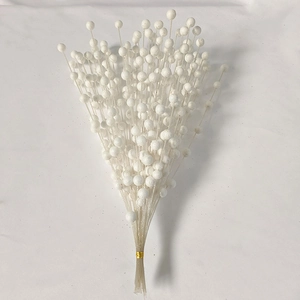 Detailed close-up of white decorative berry stems with pearlescent finish for holiday decor