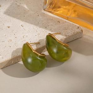 Detailansicht olivgrüner Harzohrringe mit Goldrand auf einem Naturstein