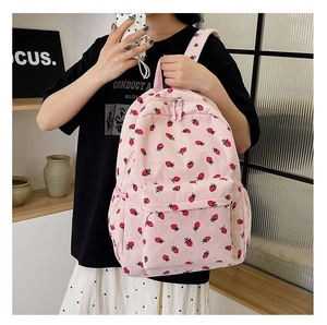Detail of pink corduroy backpack with cute strawberry pattern and front zip pocket