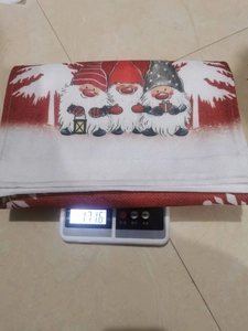 Christmas gnome holiday table runner being weighed, showing 171.6 oz on a digital scale.