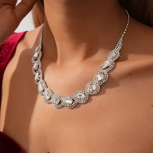 Detailed close-up of a silver water-drop necklace with sparkling rhinestones on neck