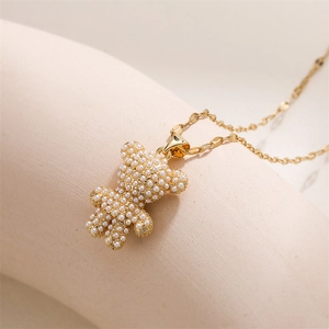 Detailed macro shot of 3D gold bear pendant with white pearls and gold chain
