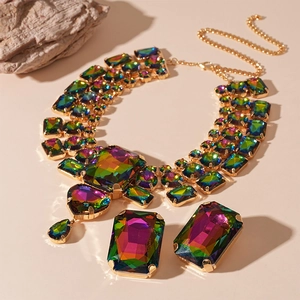 Exaggerated golden jewelry set with multicolor geometric crystals on rock background