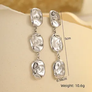 Detail of silver irregular metal drop earrings with hammer texture, 5cm length and 0.98cm width