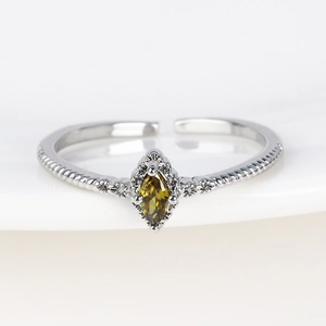 Macro shot of 18K silver ring featuring a marquise-cut yellow zircon and twisted band