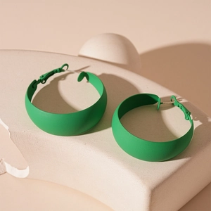 Detail view of large green matte geometric hoop earrings with modern spray finish