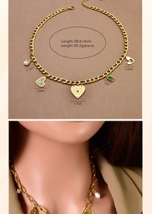 Detail of gold multi-charm necklace with heart pendants, turquoise and green gems