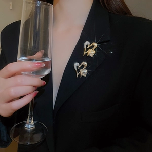 Close-up of sparkling heart-shaped diamond brooches pinned on a black blazer collar