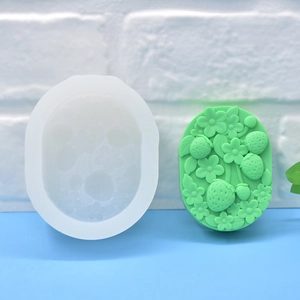 Translucent silicone mold and green strawberry flower embossed soap in a side view