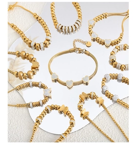 Detailed collection of gold-plated beaded bracelets with heart charms and rhinestones