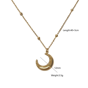 Detail view of gold moon pendant necklace with delicate bead chain on white background