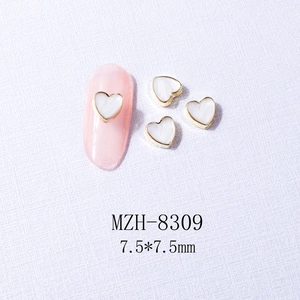 Macro view of white heart nail charm with gold metal frame, model MZH-8309, 7.5x7.5mm