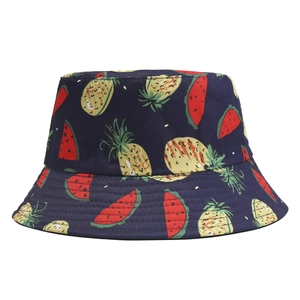 Detailed view of navy blue bucket hat with vibrant pineapple and watermelon prints