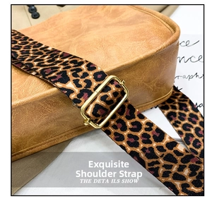 Detail of brown leather bag featuring leopard print strap and gold metal buckle
