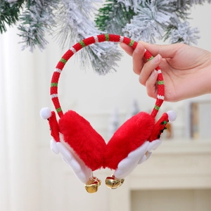 Detail of Christmas earmuffs with red Santa hat decor, white fur, and golden bells