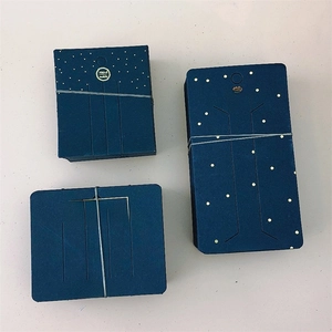 Detail of dark blue paper jewelry display cards with gold star pattern and handmade text