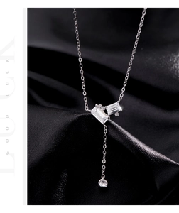 Close-up of 925 silver Y-necklace featuring emerald-cut cubic zirconia and tassel detail