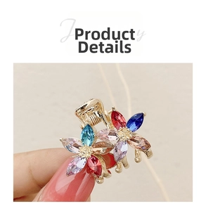 Macro detail of golden alloy hair claw with colorful rhinestone flower patterns