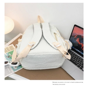 Détail des bretelles de sac à dos blanc et du tissu texturé sur un bureau moderne