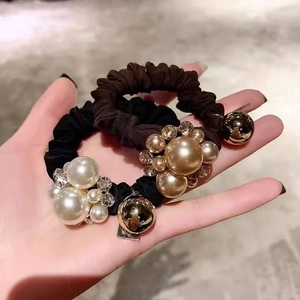 Detail of elegant hair scrunchies with large pearls, rhinestones and golden metal beads