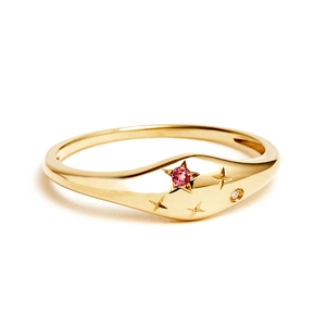 Detailed macro of gold S925 ring featuring a pink gemstone and star engravings