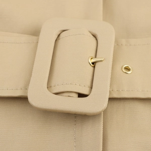 Elegant halter neck dress with beige trench-style belt and fabric-covered buckle detail