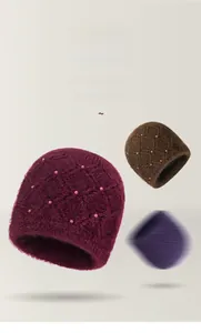 Dettaglio di cappelli in maglia con paraorecchie, trama a rombi e decoro di perle