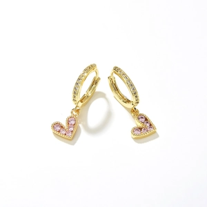 Close-up of gold heart earrings with pink zircon stone and sparkling pavé crystals