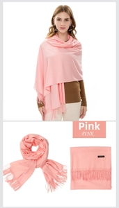Detail showing pink cashmere scarf with dense fringe tassels and authentic woven label