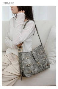 Detail of grey vintage PU leather crossbody bag with multiple buckles and wide strap