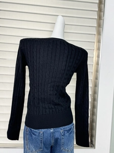 Detailed back view of a slim-fit black cable-knit sweater with ribbed hem and texture