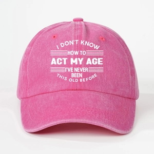 Close-up of pink washed cotton baseball cap with white printed I Don't Know How To Act My Age text