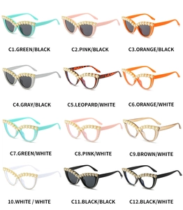 Dettaglio degli occhiali da sole cat-eye decorati con perle e fiori di strass sulla montatura