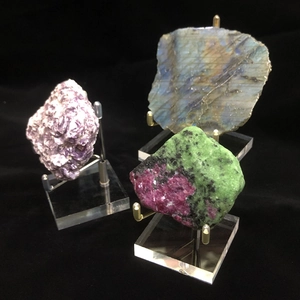Macro detail of various crystal specimens on transparent acrylic bases with metal stands