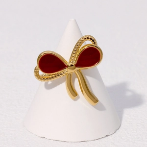 Detail of gold-plated stainless steel bow ring with vintage red enamel filling