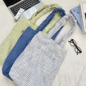 Detail of plaid canvas totes with Sozakka embroidery and ruffled elastic handles