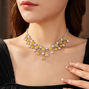 Detail of a luxury multi-layer silver necklace with yellow pear-shaped zircon pendants