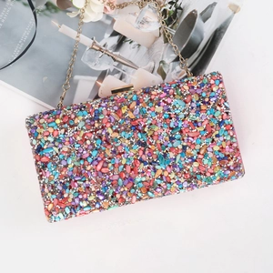 Macro shot of colorful beaded evening bag with gold chain strap on a magazine