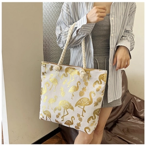 Detail of canvas tote bag with gold flamingo and pineapple print and hemp rope handles