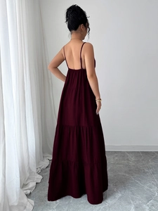 Detail of a dark red tiered sundress showing the flowing layered fabric and back design