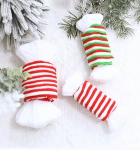 Detailed view of red and white candy cane plush ornaments on white lace fabric