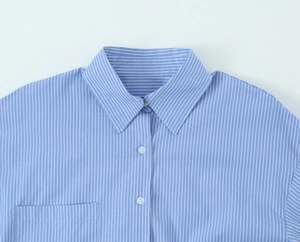 Detail shot of blue striped shirt collar and pocket with high quality stitching